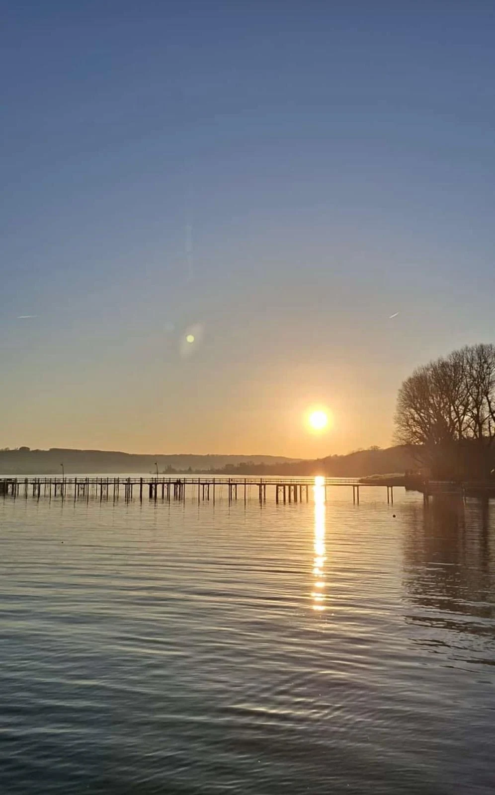 Abendsonne über dem See und einem Steg.